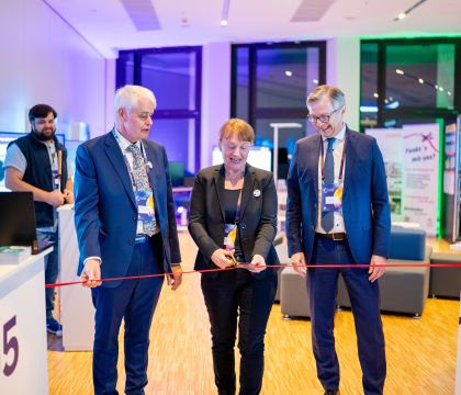 Wolfgang Schmülling, Uta Knöchel und Dr. Heiko Geue durchschneiden das rote Band zur Eröffnung des DVZ-Messebereichs