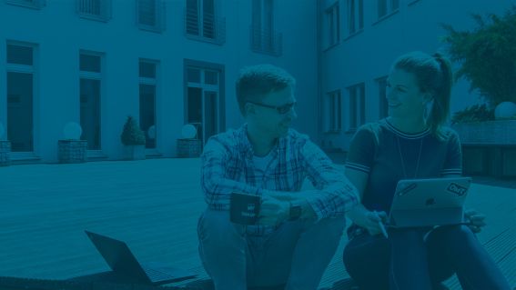 Zwei Menschen sitzen auf einer Terrasse und reden