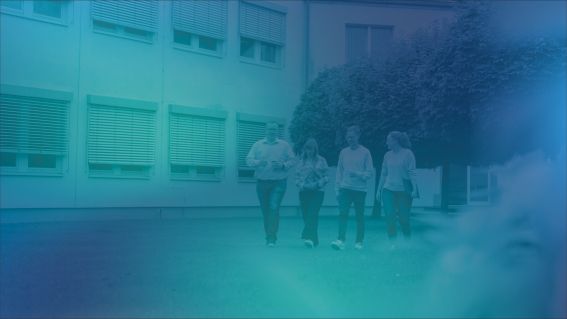 Foto von vier DVZ Mitarbeiter*innen, die im Innenhof gehen, blau eingefärbt