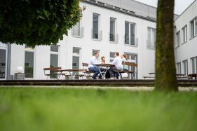 DVZ Mitarbeiter*innen sitzen im Innenhof