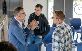 Bild von Finanz- und Digitalisierungsminister Dr. Heiko Geue im Gespräch mit zwei Personen