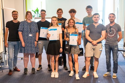 Foto: Die Praktikant*innen des Sommer Bootcamps mit ihren Teilnahmeurkunden sowie die DVZ-Mitarbeiter*innen, die sie während des Bootcamps betreut haben.