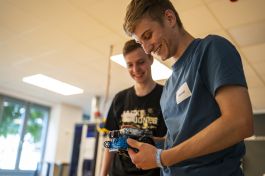 Schüler tüfteln am Roboter und lachen