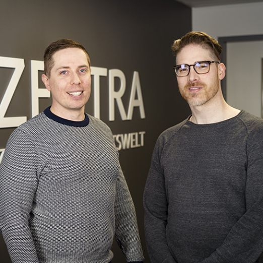 Foto von Dennis Schramm und Ralf Lorenz vor dem ZENTRA-Logo stehend