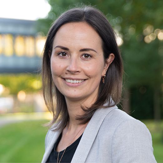 Portrait: Annemarie Guse, DVZ-Ausbildungskoordinatorin, steht vor dem Hauptgebäude des DVZ und lächelt in die Kamera.