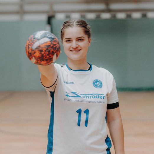 Dora Konrad hält einen Handball vor sich. Sie trägt ein Trikot.