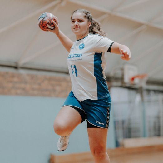 Dora Konrad springt in die Luft und hält dabei einen Handball in der Hand