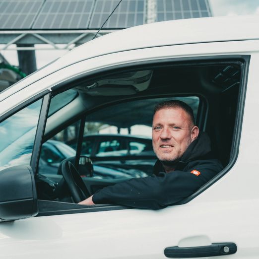 Frank Burmeister fährt mit seinem Auto an der Photovoltaik-Anlage vorbei.
