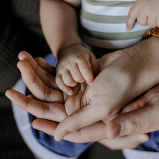 Foto von den Händen eines Paares mit einem Baby