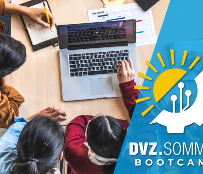 Foto: Mehrere Schüler arbeiten an einem Laptop