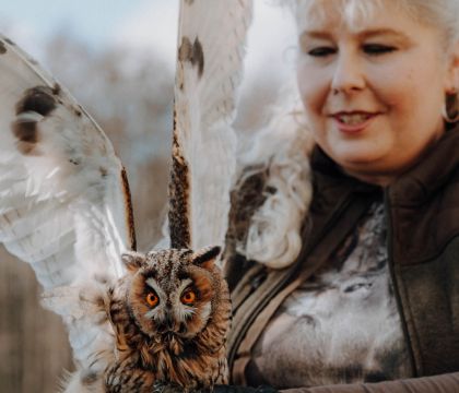 DVZ-Mitarbeiterin Sylwia Engler trägt eine Eule auf ihrem Arm.